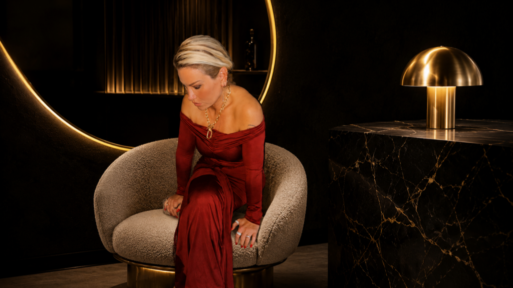 Sera in rotem Kleid im goldenen Salon-Interieur – Inhaberin von SERA'S CUT