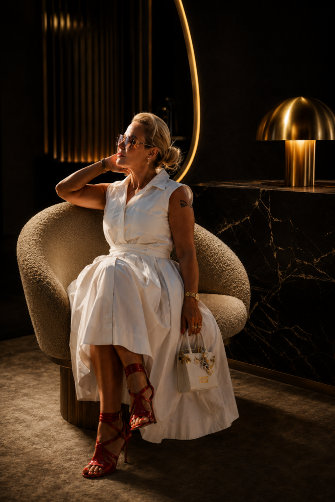 Sera in weißem Kleid im Sessel des Salons – SERA'S CUT Berlin